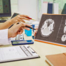 Three doctors sit together at a hospital desk, discussing bone health topics like osteoarthritis